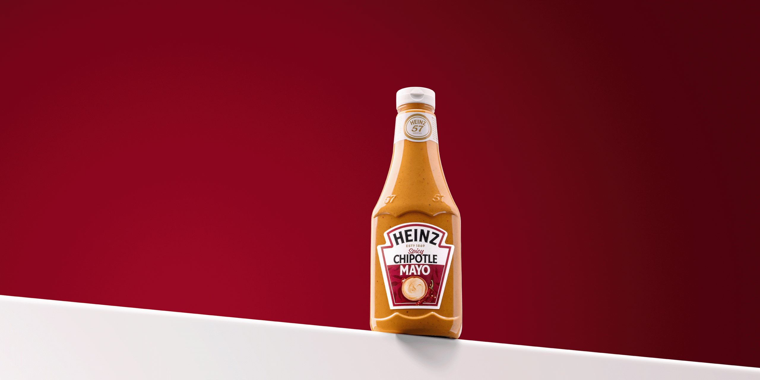 Profesjonalny packshot żywności wykonany przez PackshotHouse - butelka sosu Heinz na gradientowym czerwonym tle