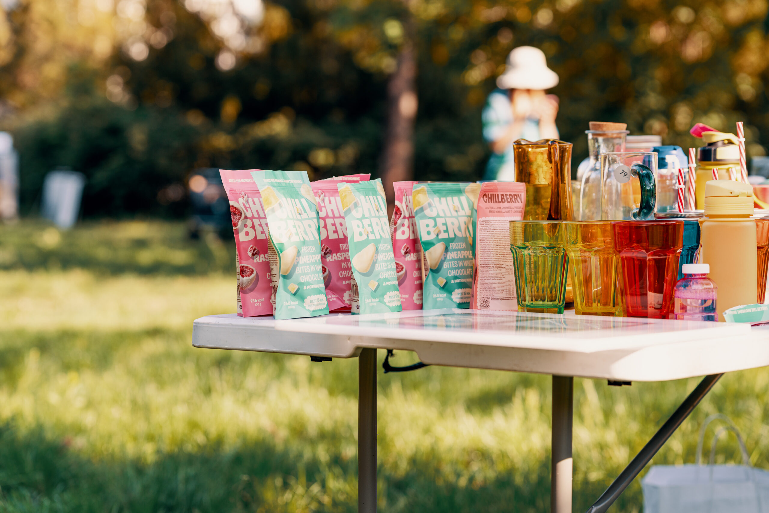 Produkty Chillberry i kolorowe napoje przygotowane na stole na planie filmu reklamowego w parku