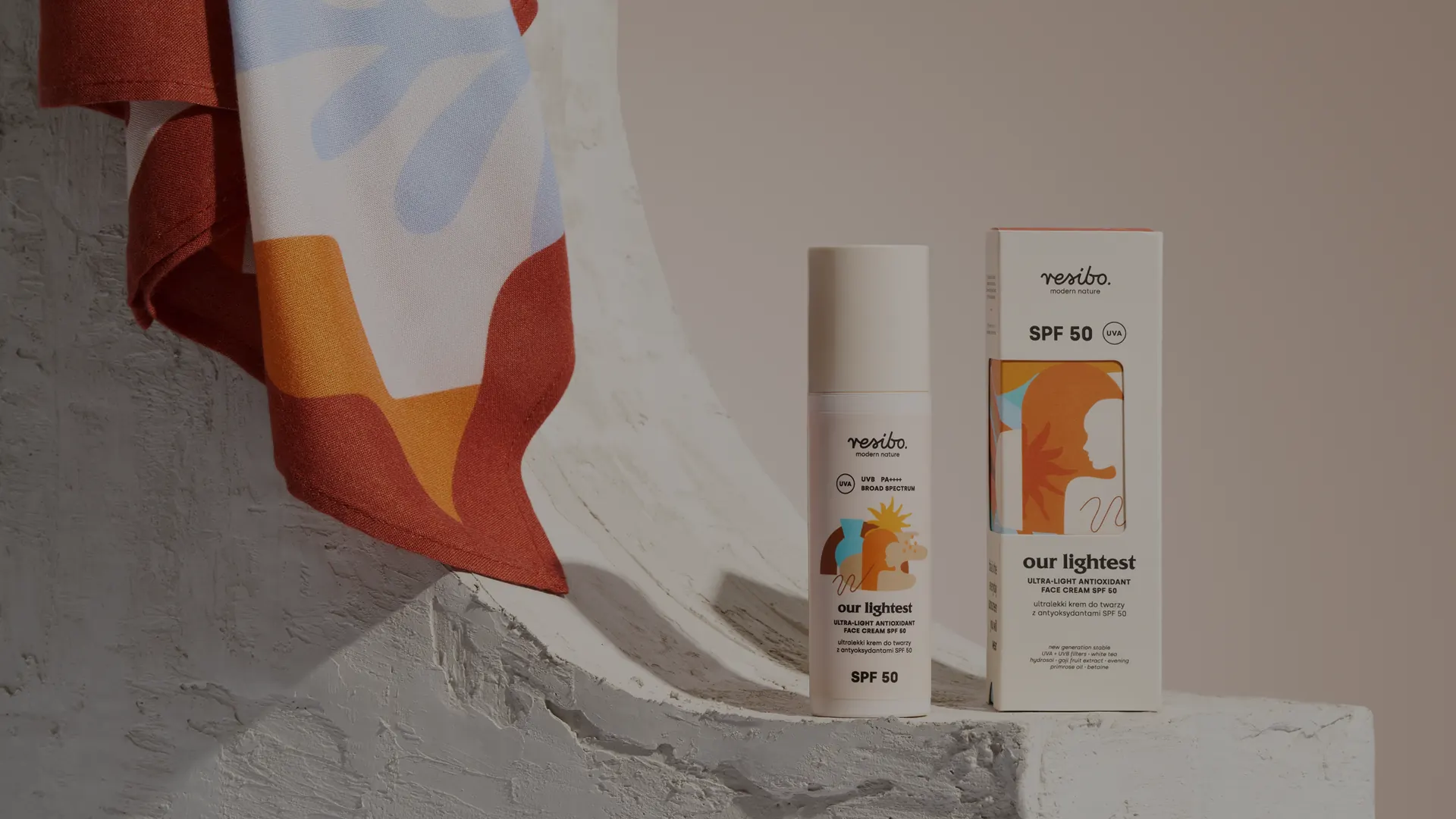 Zdjęcie aranżowane kosmetyku — krem z filtrem SPF 50 marki Resibo z opakowaniem na jasnej scenografii