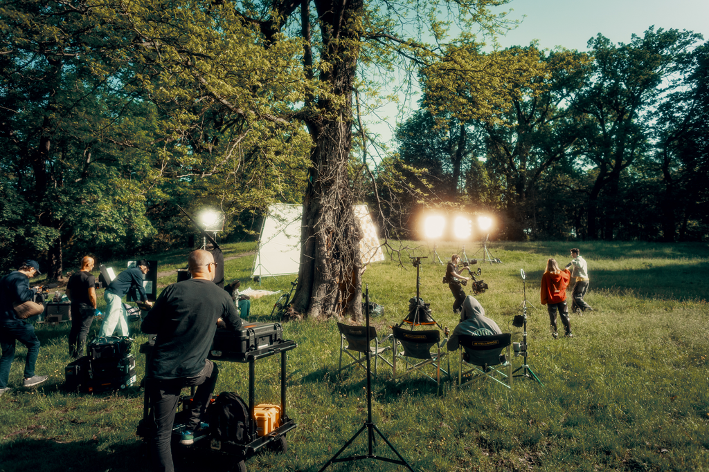 Plan zdjęciowy spotu reklamowego Chillberry realizowany w Warszawskim plenerze – reżyser przy monitorze i oświetlenie filmowe